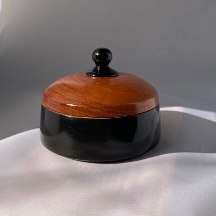 Wooden box with a black base and a brown lid, topped with a black knob.