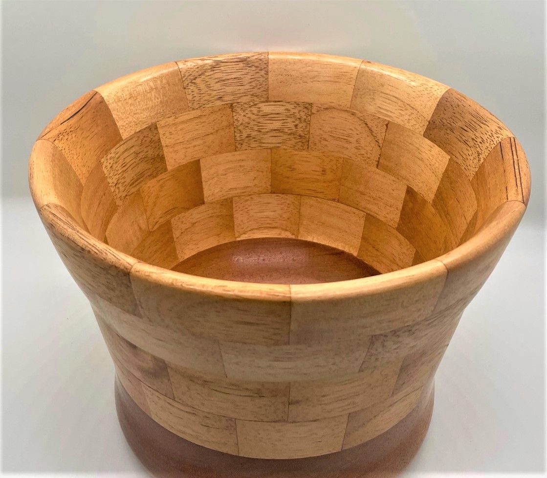 Wooden salad bowl with a light and dark checkerboard pattern. The bowl sits on a dark brown base.