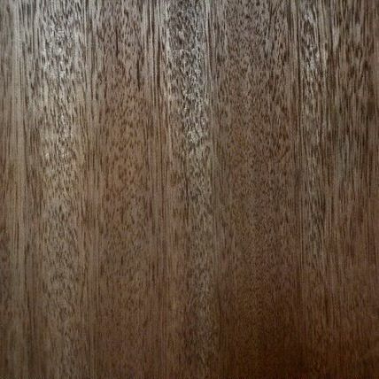 Close-up of a wooden surface with a dark brown, vertical grain pattern, showcasing the texture and natural lines of the wood.