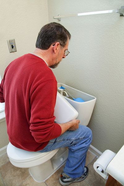 Plumber fixing toilet