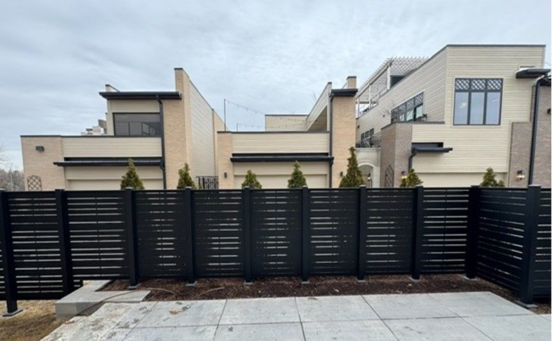 A large house with a black fence in front of it.