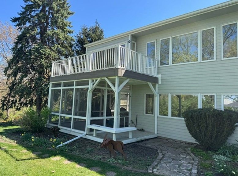 A house with a screened in porch and a large deck