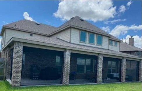 A large house with a screened in porch and a lot of windows.