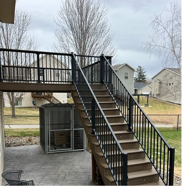 A set of stairs leading up to a deck with a metal railing