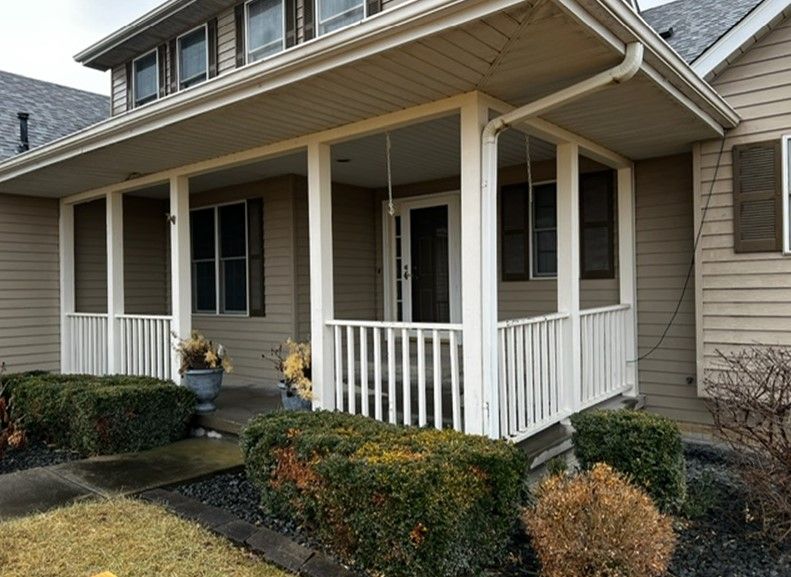 A house with a screened in porch and a white railing