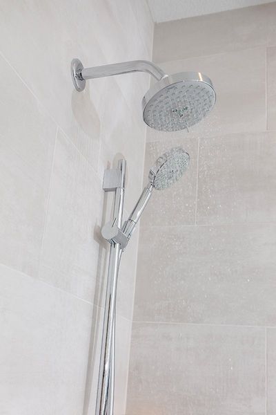 A close up of a shower head in a bathroom.