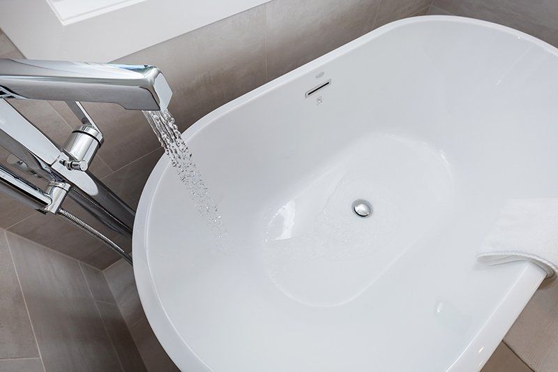 A bathtub is being filled with water from a faucet.
