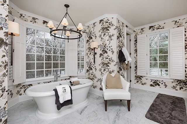 A bathroom with a tub and a chair in it