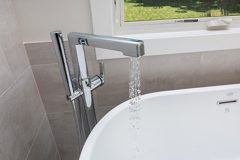 A bathtub with water running from a faucet in a bathroom.