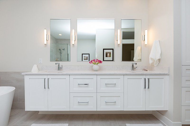 A bathroom with two sinks , two mirrors and a tub.