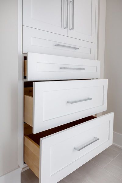 A white dresser with the drawers open and empty