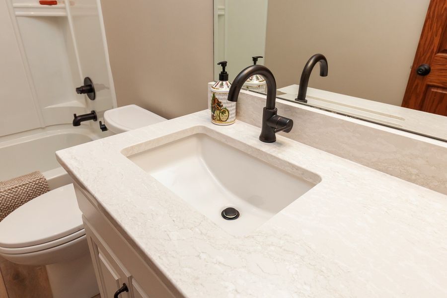 A bathroom with a sink , toilet , and mirror.