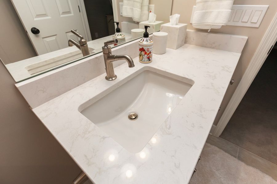 A bathroom sink with a faucet and a mirror.