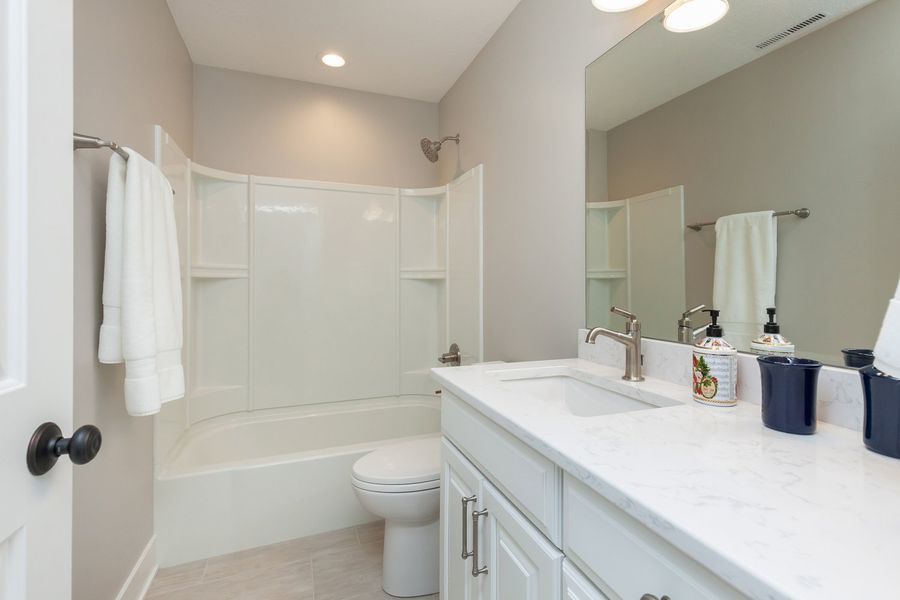 A bathroom with a sink , toilet , bathtub and mirror.