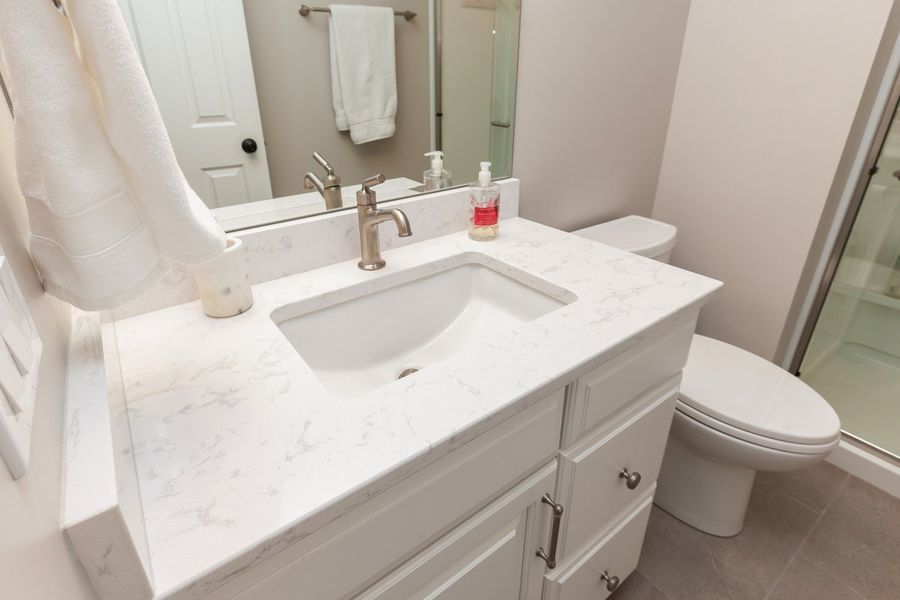 A bathroom with a sink , toilet and mirror.
