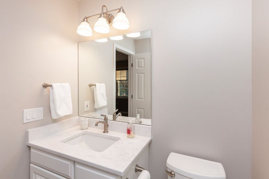 A bathroom with a sink , toilet and mirror.
