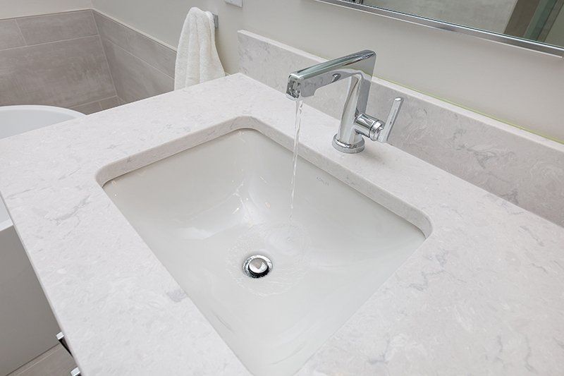 A bathroom sink with water running from the faucet.