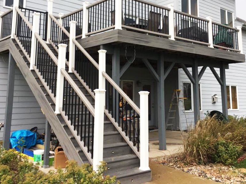 A house with a deck and stairs leading up to it.