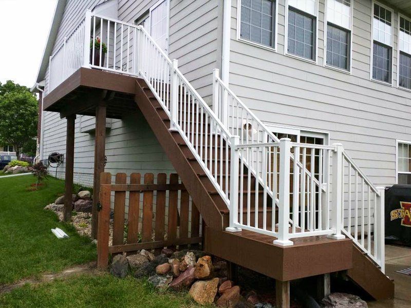 A house with a deck and stairs leading up to it.