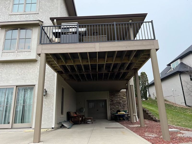 A large house with a large deck underneath it.