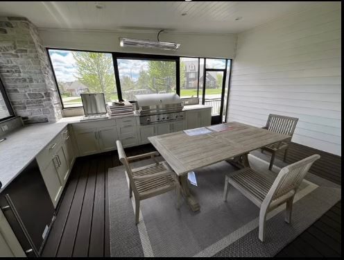 A dining room with a table and chairs and a grill.