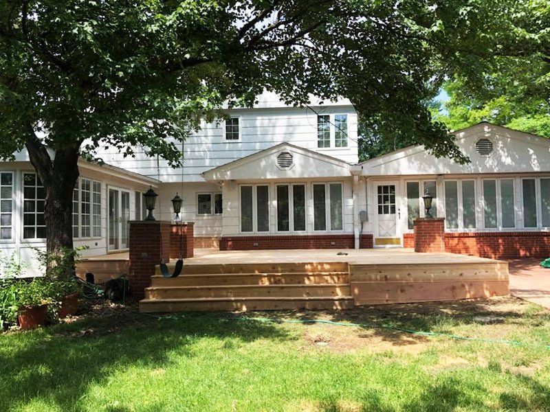 A large white house with a large deck in front of it.