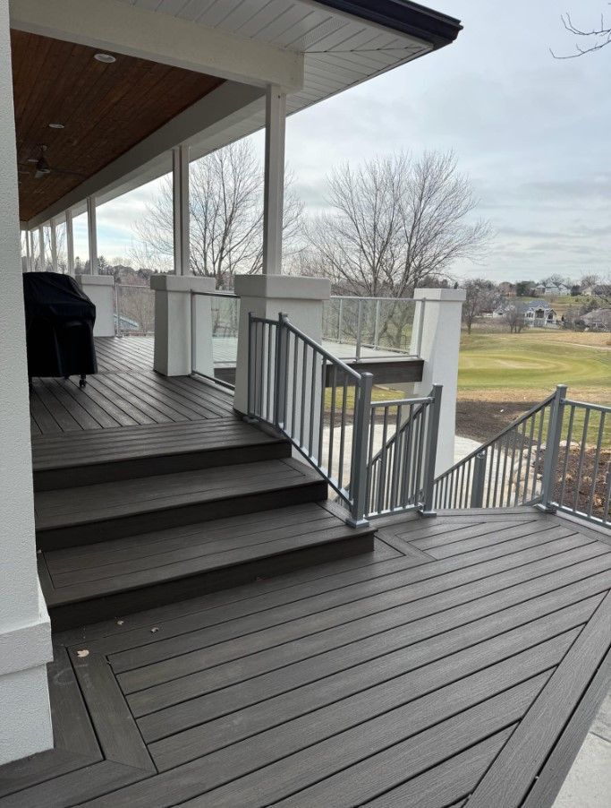 A deck with stairs leading up to it and a view of a golf course.