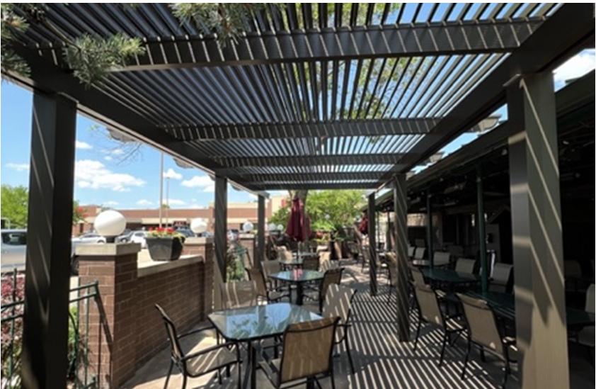 A patio with tables and chairs under a pergola