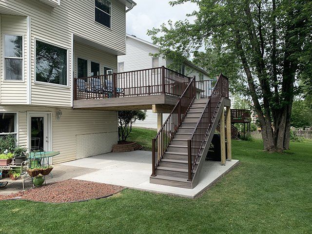 A house with a deck and stairs in the backyard.