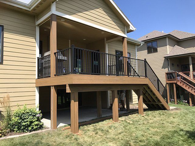 A large house with a large deck and stairs.