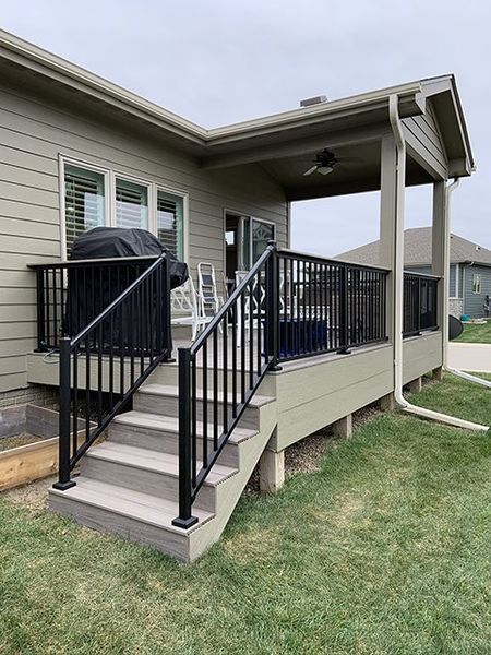 A house with a deck and stairs in front of it.