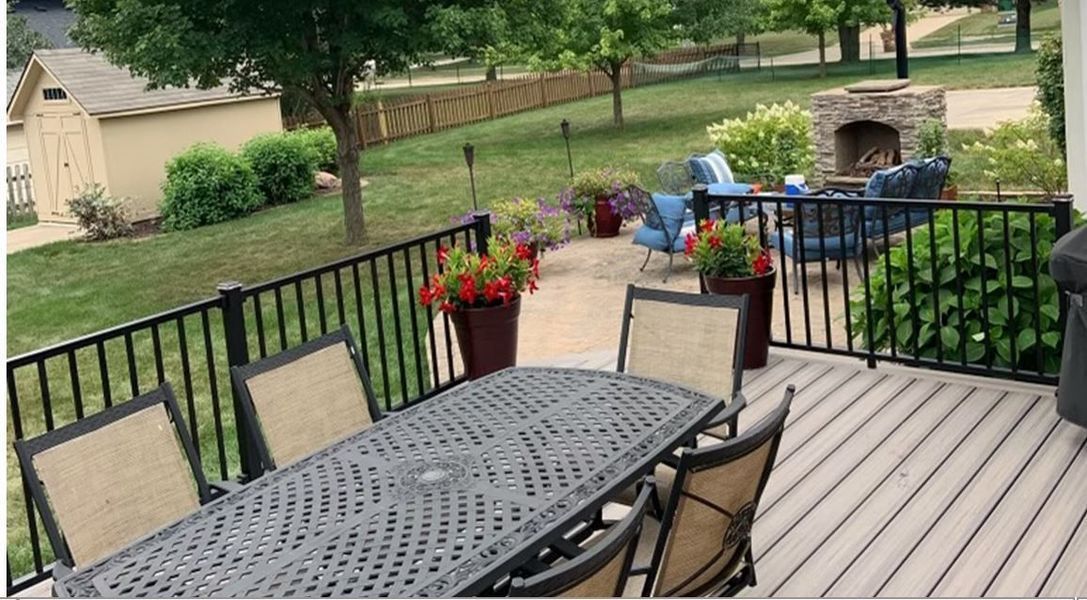 A deck with a table and chairs and a fireplace.