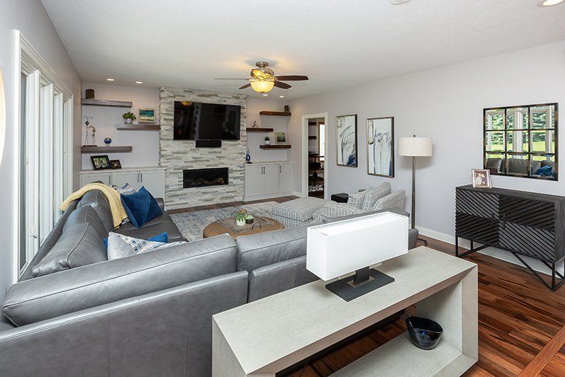 A living room with a couch , table , lamp and fireplace.