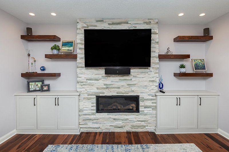 A living room with a fireplace and a flat screen tv on the wall.