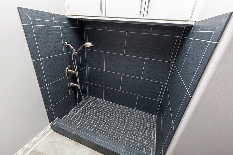 A bathroom with a walk in shower and two shower heads.