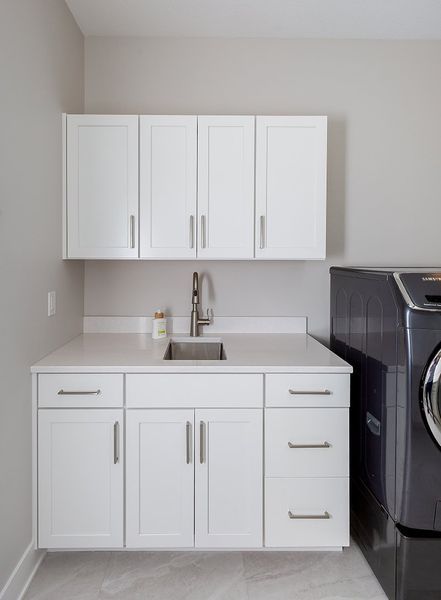 A laundry room with white cabinets and a washer and dryer