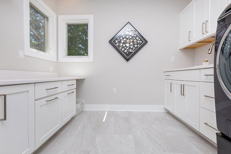 A laundry room with white cabinets and a washer and dryer.