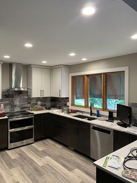 A kitchen with stainless steel appliances and wooden floors.