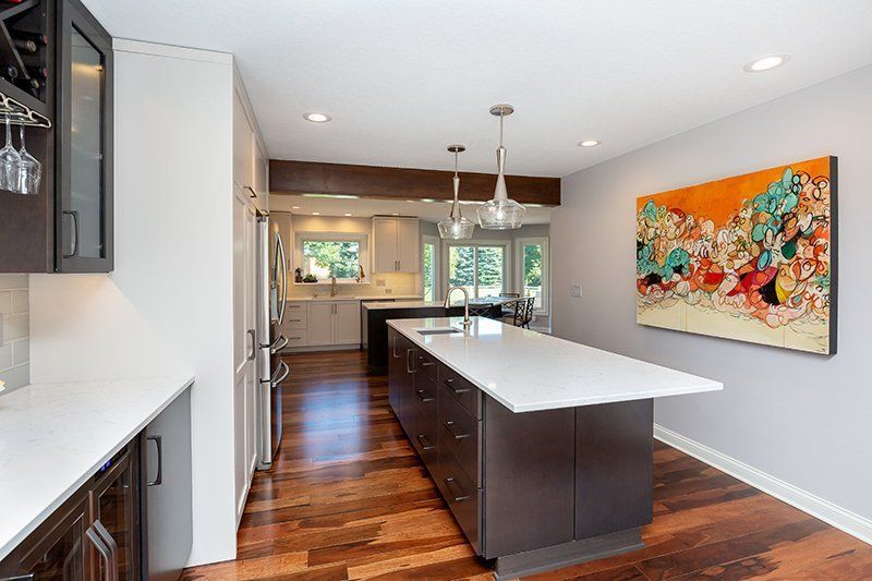 A kitchen with a large island and a painting on the wall.