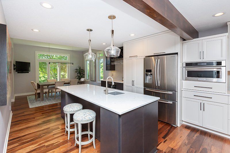 A kitchen with stainless steel appliances and a large island in the middle.