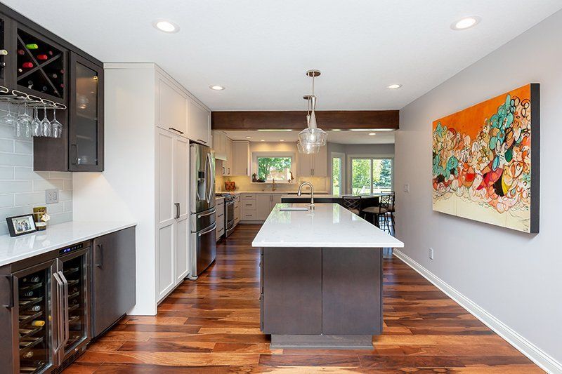 A kitchen with a large island and a painting on the wall.
