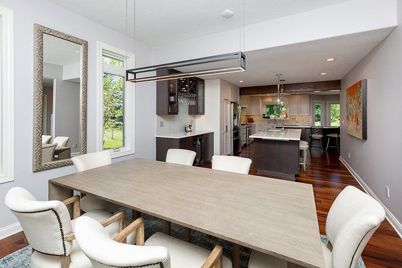 A dining room with a long table and white chairs