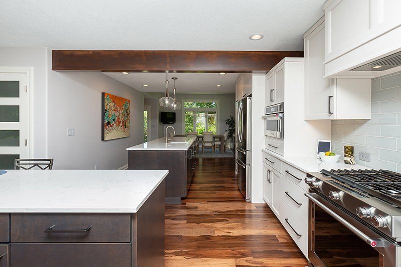 A kitchen with a large island , stove , refrigerator and microwave.
