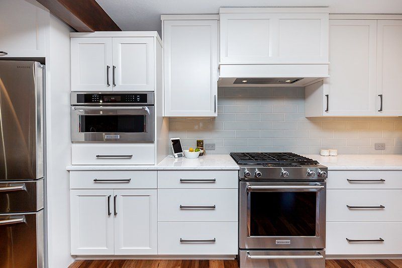 A kitchen with white cabinets and stainless steel appliances.