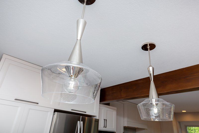 A kitchen with two pendant lights hanging from the ceiling