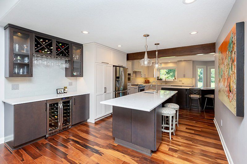 A kitchen with hardwood floors and a large island in the middle.