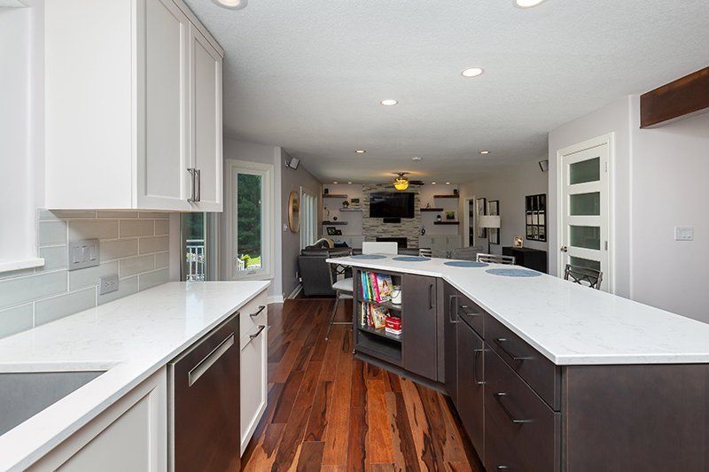 A kitchen with white cabinets and a large island in the middle.