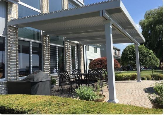 There is a patio with a table and chairs under a canopy.