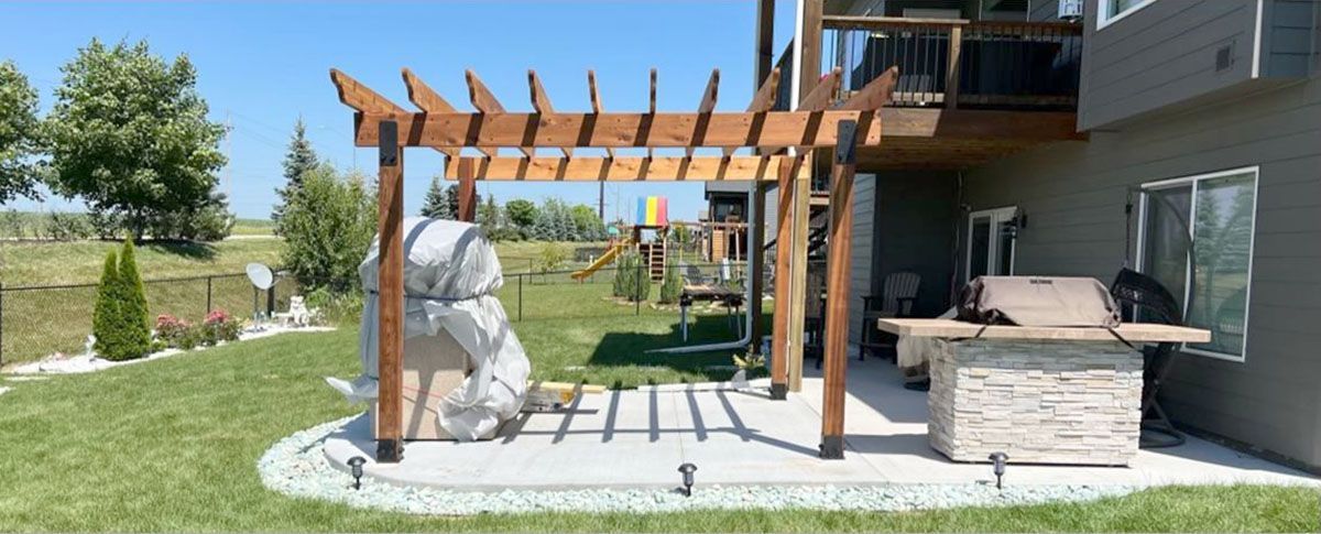 There is a pergola in the backyard of a house.