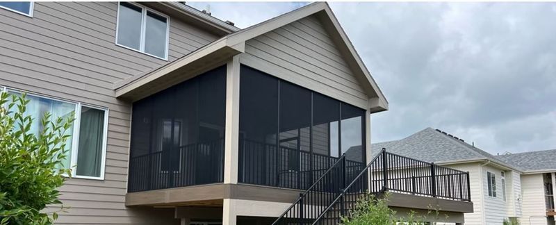 A house with a screened in porch and stairs.